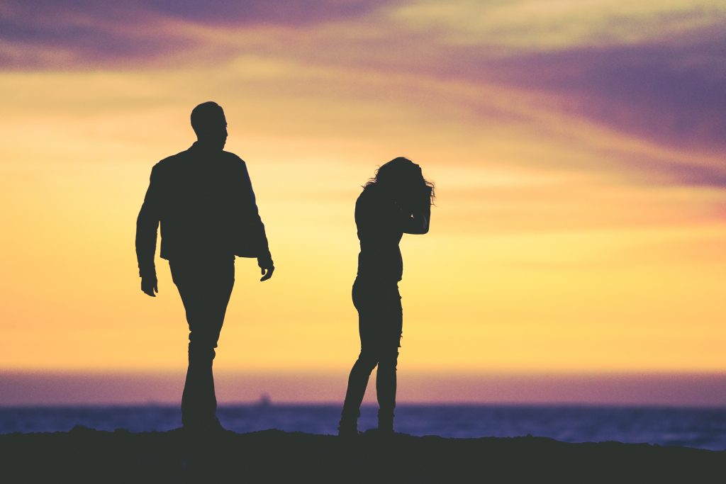 silhouette of man and woman against sunset